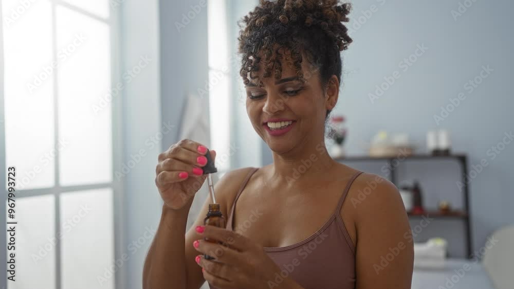 Brunette woman smiling while using essential oil dropper in an indoor wellness spa center Brunette woman smiling while using essential oil dropper in an indoor wellness spa center