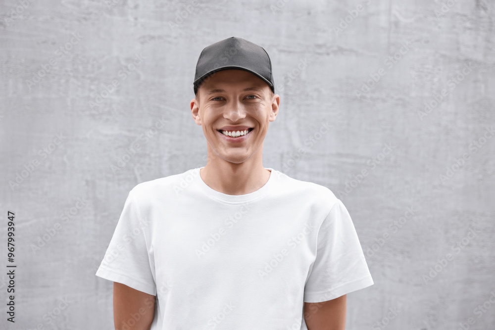 Portrait of smiling man in baseball cap near light wall Portrait of smiling man in baseball cap near light wall