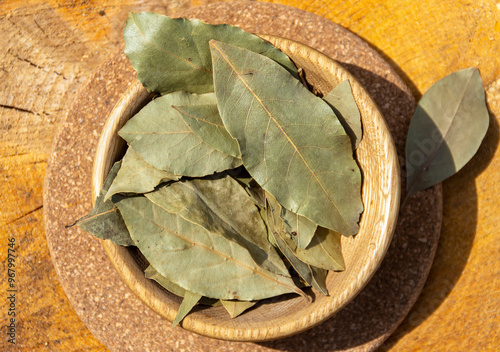 Dried bay leaf in a wooden cup. Spices and seasonings, cooking photo