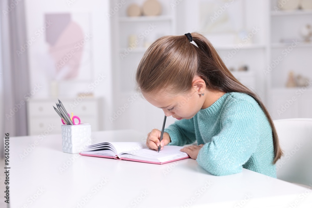 Girl with incorrect posture doing homework at white desk indoors Girl with incorrect posture doing homework at white desk indoors