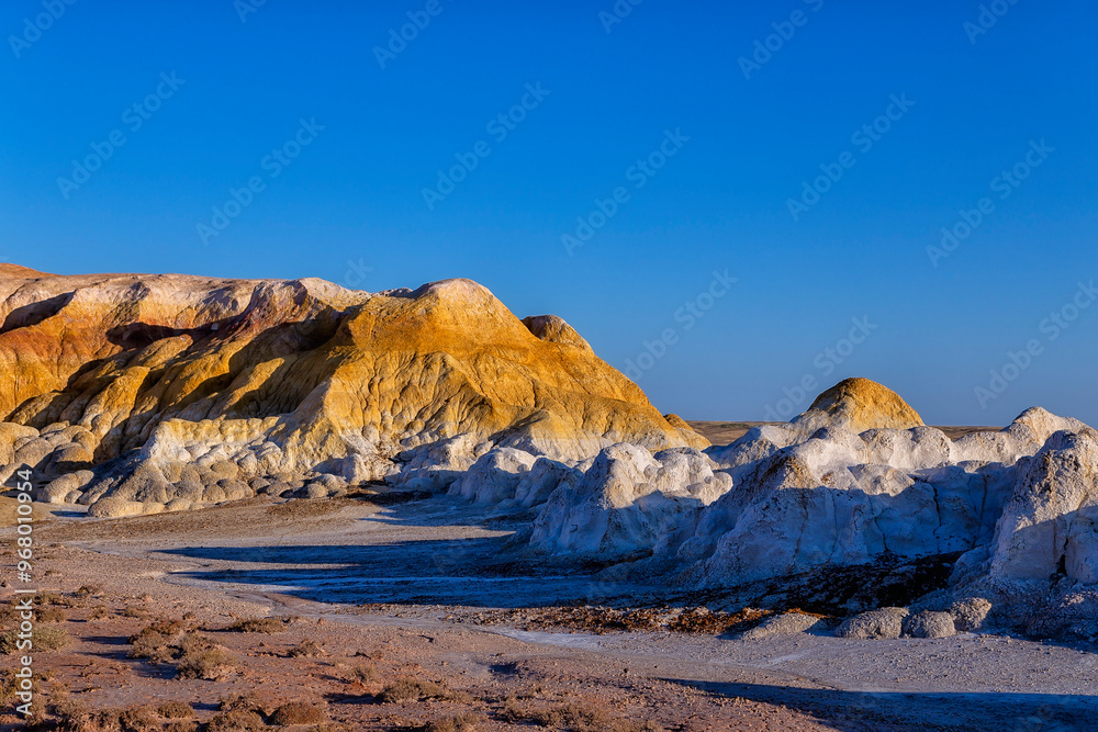 Akzhar Ulytau chalk mountains in the desert of Kazakhstan. Rare sandy hills with many multi-colored layers of clay, sand, chalk and gravel of bizarre shape far from civilization with sparse vegetation Akzhar Ulytau chalk mountains in the desert of Kazakhstan. Rare sandy hills with many multi-colored layers of clay, sand, chalk and gravel of bizarre shape far from civilization with sparse vegetation