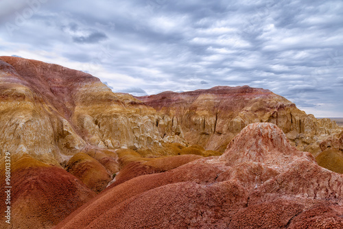 Akzhar Ulytau chalk mountains in the desert of Kazakhstan. Rare sandy hills with many multi-colored layers of clay, sand, chalk and gravel of bizarre shape far from civilization with sparse vegetation photo