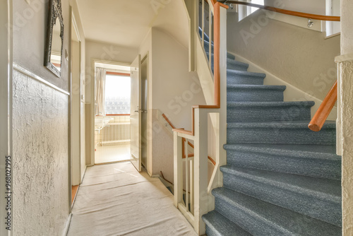 Bright home interior with carpeted staircase and hallway photo