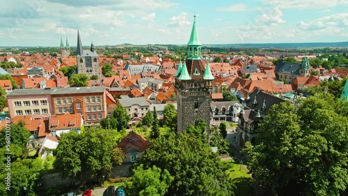 Wallpaper Mural Vibrant town with traditional red-roofed buildings and historic towers dominates the view under bright sunshine. Torontodigital.ca