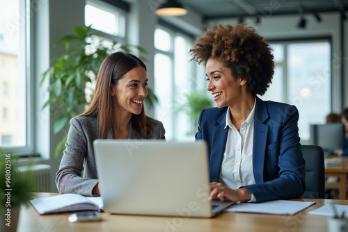 Two busy happy professional business woman and woman executive leaders team using laptop working on computer at work desk having conversation on financial project at meeting in office