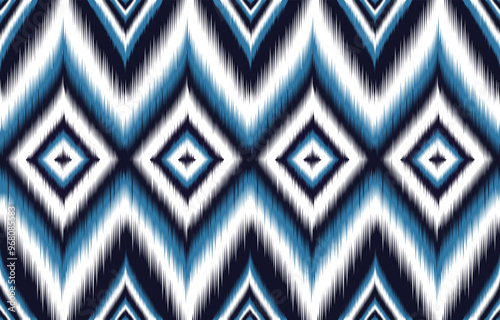 Blue and white ikat pattern. Seamless chevron design with diamond motifs. Trendy ethnic print for fashion and interiors. Abstract geometric background. Bohemian style textile. Aztec-inspired artwork. photo