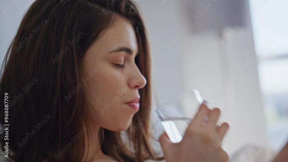 Sleepy girl sipping water from glass feeling sleepless at light bedroom closeup. Sleepy girl sipping water from glass feeling sleepless at light bedroom closeup.