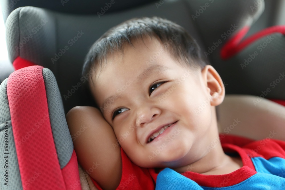 Asian boy about one year old sitting in a car seat, smiling and laughing happily. Asian boy about one year old sitting in a car seat, smiling and laughing happily.