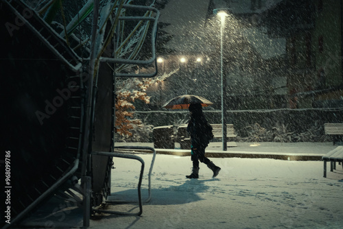 Canvas Print Person walking in the city during a snowfall on New Years Eve, moody ambience, A