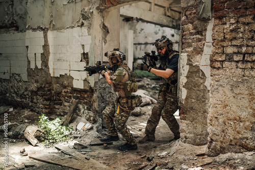 Few air soft players in formation attacking enemy in ruined building.