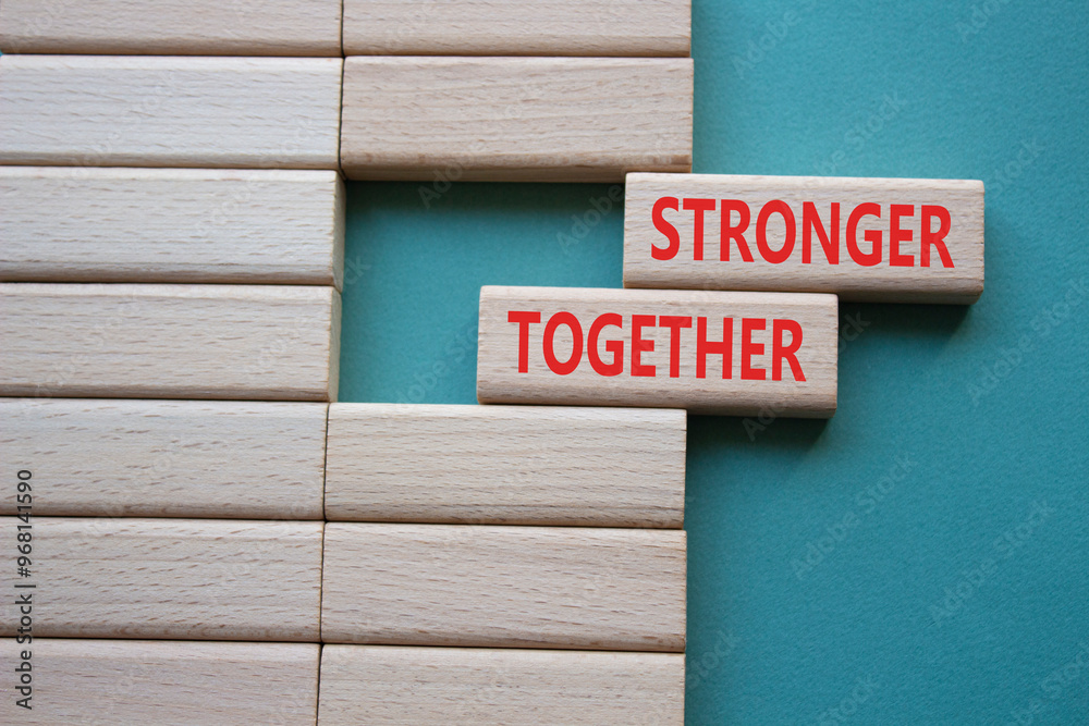 Stronger together symbol. Wooden blocks with words Stronger together. Beautiful grey green background. Stronger together concept. Copy space. Stronger together symbol. Wooden blocks with words Stronger together. Beautiful grey green background. Stronger together concept. Copy space.
