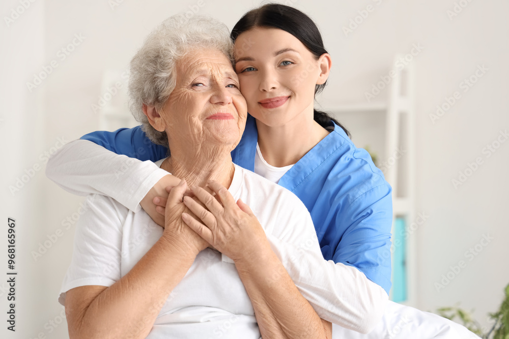 Female nurse hugging senior woman in bedroom Female nurse hugging senior woman in bedroom