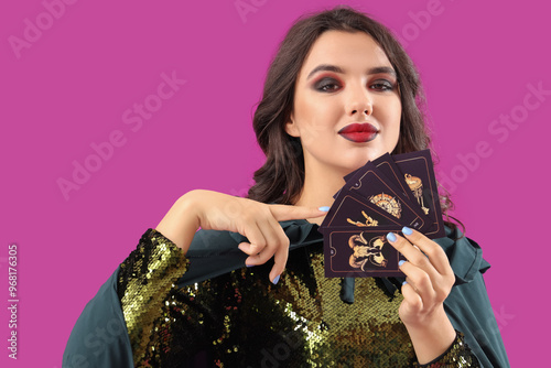 Young witch with tarot card...