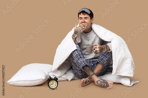Tattooed young man in pajam...