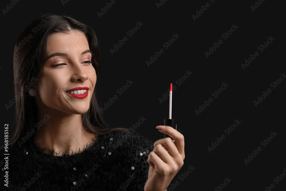 Obraz premium Beautiful young woman with red lipstick on black background