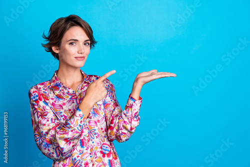 Photo of stunning adorable girl wear stylish clothes arms hold novelty recommend buy product empty space isolated on blue color background