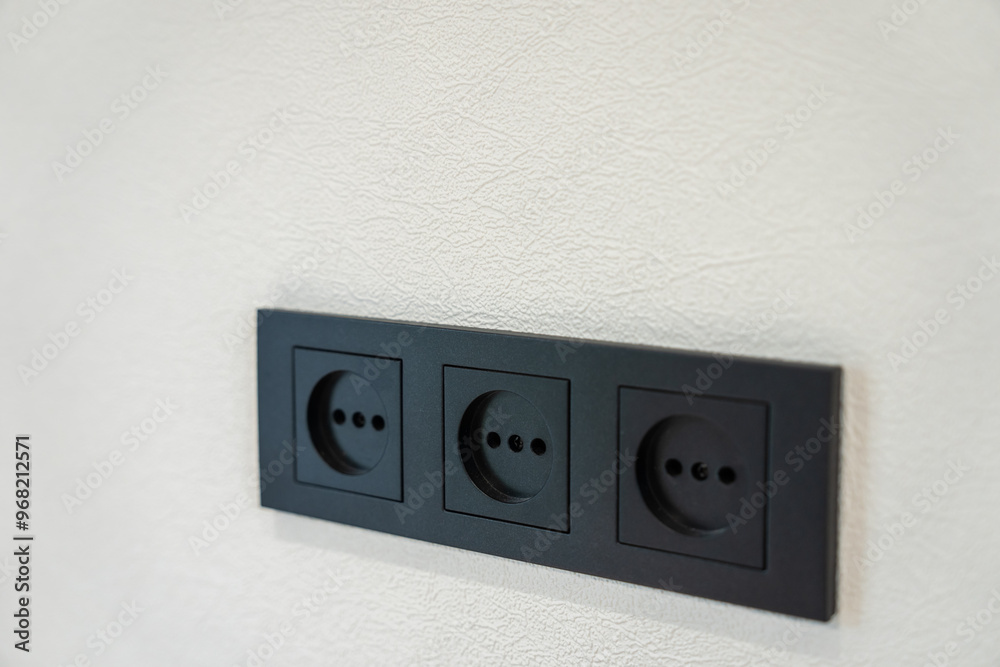 Black three sockets on the wall, design concept Black three sockets on the wall, design concept