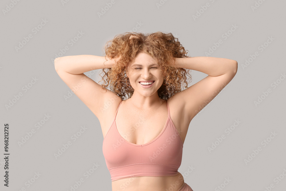 Fototapeta premium Beautiful young happy body positive woman in trendy underwear on grey background