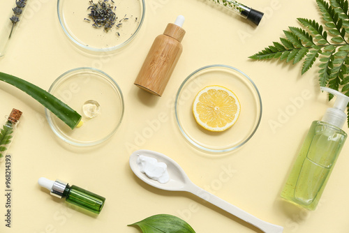 Bottles of products, Petri dishes with samples and ingredients for preparing natural cosmetics on yellow background