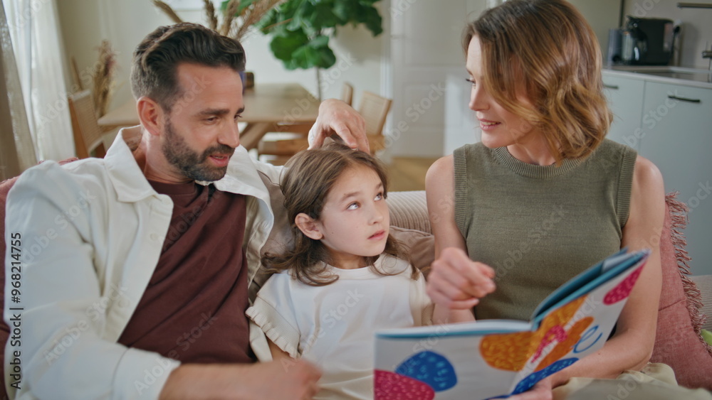 Obraz premium Caring parents communicating daughter at couch closeup. Family reading book