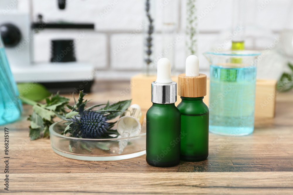 Laboratory glassware and microscope with ingredients for preparing natural cosmetics on brown wooden table near white brick wall Laboratory glassware and microscope with ingredients for preparing natural cosmetics on brown wooden table near white brick wall