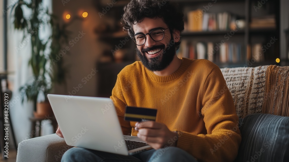 A person happily shopping online with a credit card at home in cozy evening light