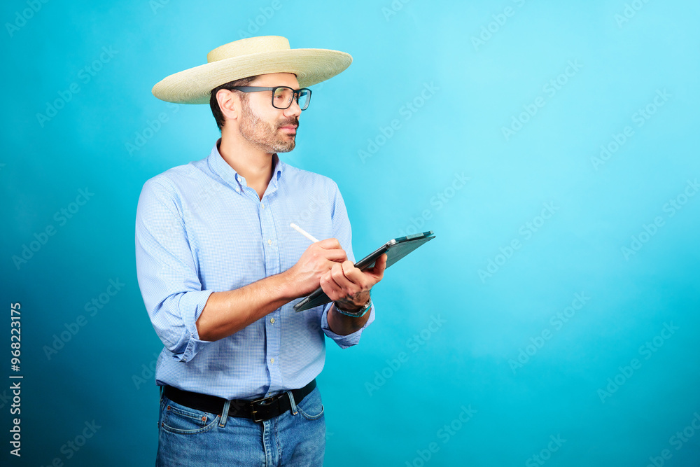 Hombre con sombrero tradicional Chupalla sosteniendo un lápiz y tableta digital , concepto de celebración de fiestas patrias Chile