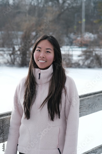 Chinese woman in cozy winter clothing posing in snowy Gallup Park Ann Arbor Michigan photo