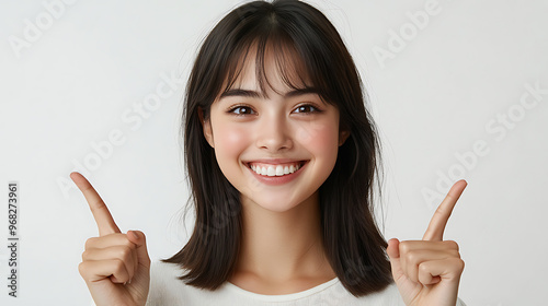 A woman with long black hair is smiling and pointing to the right