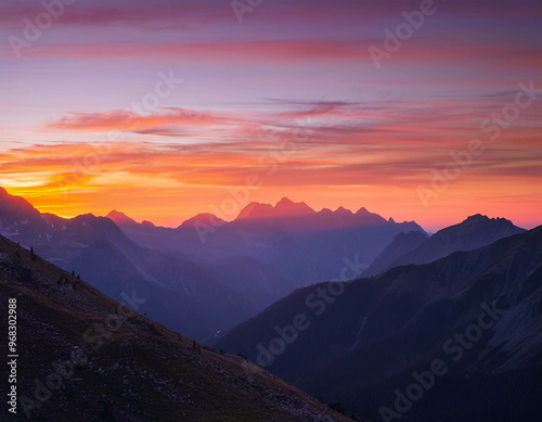 A breathtaking view of a mountain range at sunset, with the sky painted in shades of orange,