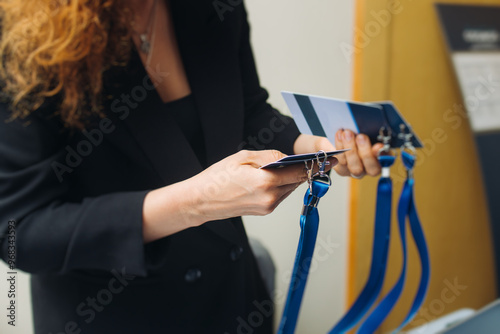 Process of checking in on conference congress forum event, registration desk table, visitors and attendees receiving lanyard with name badge and entry wristband bracelet and register electronic ticket