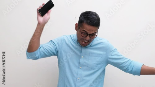 A man showing very angry expression and smashing his phone to the floor