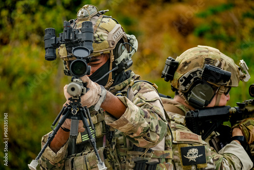 A group of military men in combat gear patrol in the middle of a desert and tropical jungle. Soldiers in full combat gear in dry weather conditions assemble and march on a mission.