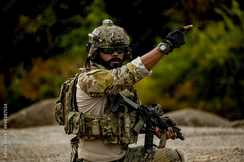 Fototapeta premium A group of military men in combat gear patrol in the middle of a desert and tropical jungle. Soldiers in full combat gear in dry weather conditions assemble and march on a mission.
