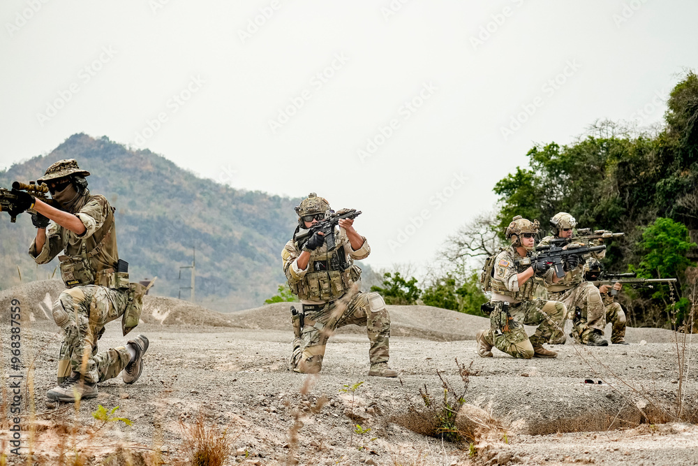 A group of military men in combat gear patrol in the middle of a desert and tropical jungle. Soldiers in full combat gear in dry weather conditions assemble and march on a mission. A group of military men in combat gear patrol in the middle of a desert and tropical jungle. Soldiers in full combat gear in dry weather conditions assemble and march on a mission.