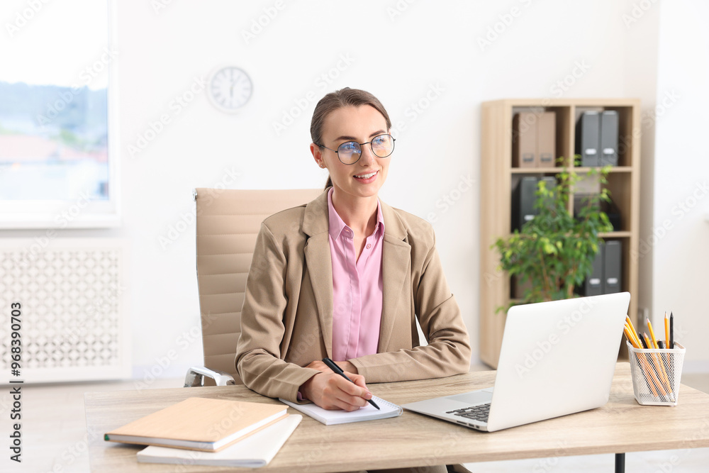 Smiling businesswoman working at table in office Smiling businesswoman working at table in office