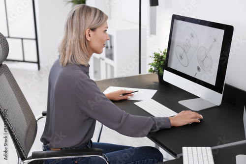 Architect making digital engineering drawing on computer at table in office