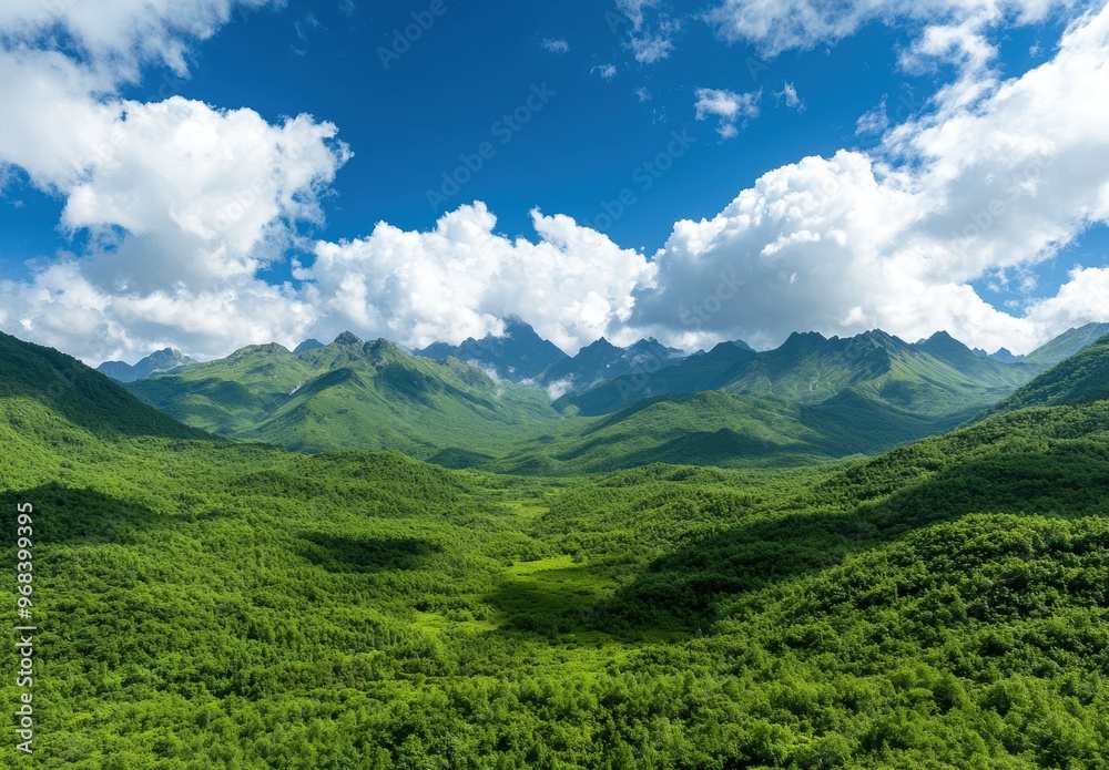 Naklejka premium Lush green mountain landscape with blue sky and clouds
