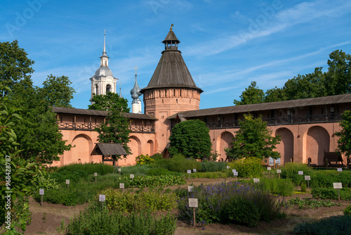 View of the towers and walls of the Spaso-Evfimiev Monastery and the Apothecary garden on the territory of the architectural and museum complex on a sunny summer day, Suzdal, Vladimir region, Russia photo