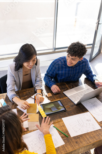 At office, Collaborating on project, diverse team using laptop, tablet, and color swatches