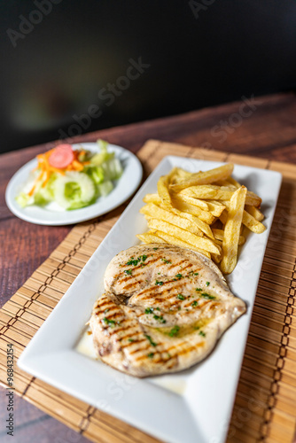 grilled chicken with french fries and fresh salad, accompanied by homemade creams.