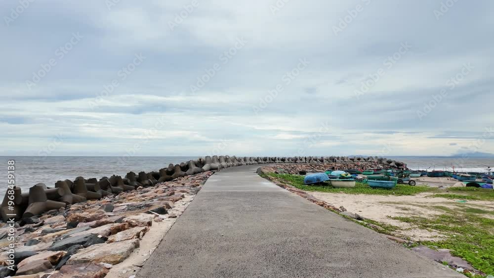 Massive concrete blocks to protecting seaside, powerful breakwall or breakwater as seawall for safe seashore from large waves at Phan Thiet, Binh Thuan Massive concrete blocks to protecting seaside, powerful breakwall or breakwater as seawall for safe seashore from large waves at Phan Thiet, Binh Thuan