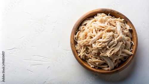 Boiled shredded chicken meat is presented in a wooden bowl seen from an overhead perspective against a white background, nutrition, isolated, chicken meat, shredded, white background