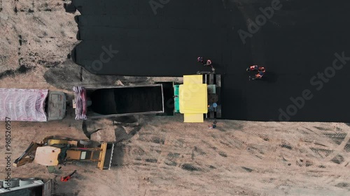 Asphalt paver laying a new road, Top down aerial view