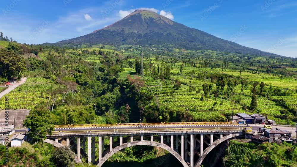 Aerial view of the Sigandul Bridge and Mount Sindoro in the background. Temanggung, Indonesia. Aerial view of the Sigandul Bridge and Mount Sindoro in the background. Temanggung, Indonesia.