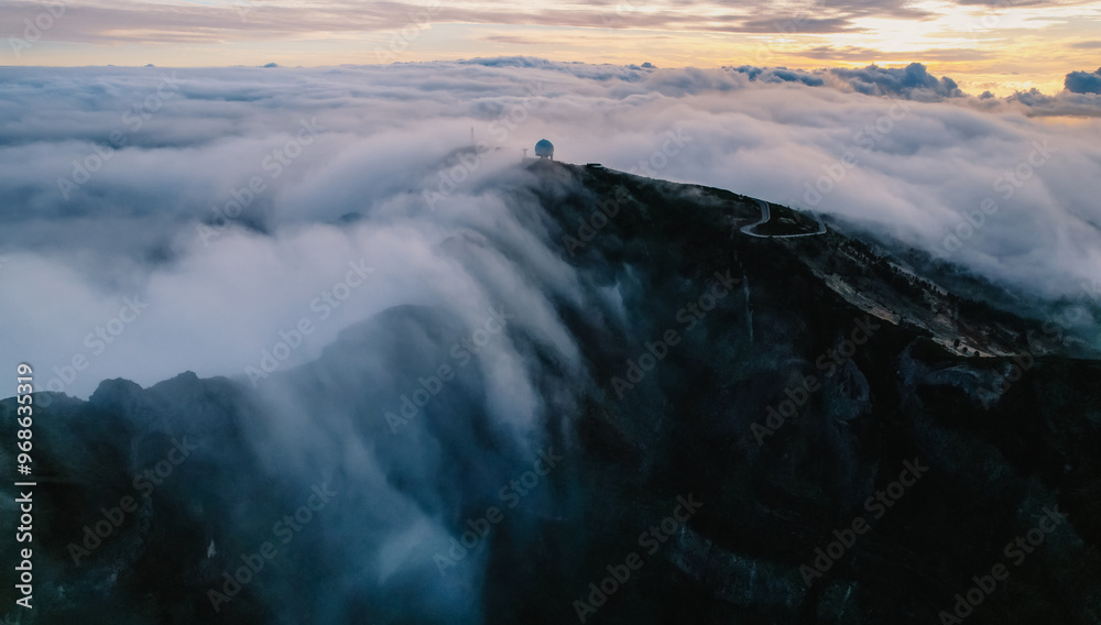 Obraz premium Aerial view of majestic mountain ridges at sunrise with falling fog from top of Pico do Areeiro, Madeira island, Portugal