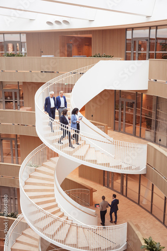 High angle view of corporate coworkers moving down on steps in modern office
