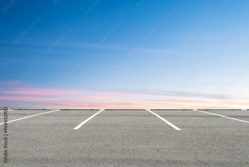 Fototapeta premium Empty parking lot against beautiful sunset sky.