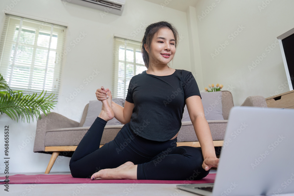 Woman practicing yoga with laptop in cozy home setting Woman practicing yoga with laptop in cozy home setting