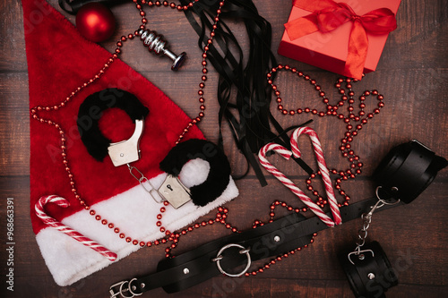 A set of adult BDSM toys with Christmas decor. Flatley. Handcuffs, whip, anal plug, Christmas balls.